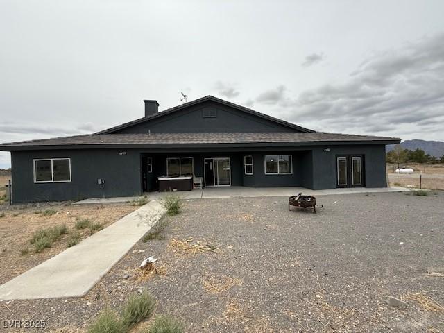 1830 Justine Ct, Pahrump, NV 89048 - back of house featuring an outdoor fire pit, a patio area, a hot tub, and stucco siding