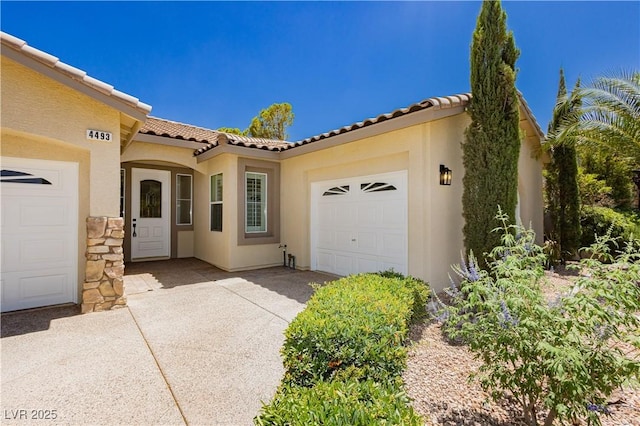4493 Rometta Ave, Las Vegas, NV 89141 - view of front of home with a tile roof, an attached garage, stucco siding, and concrete driveway