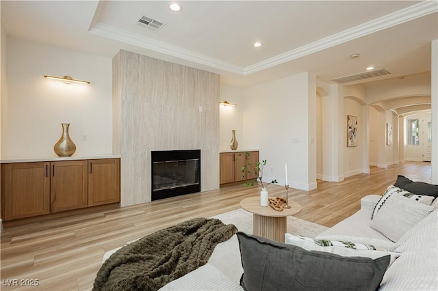 4493 Rometta Ave, Las Vegas, NV 89141 - living area with arched walkways, light wood-type flooring, ornamental molding, a large fireplace, and recessed lighting