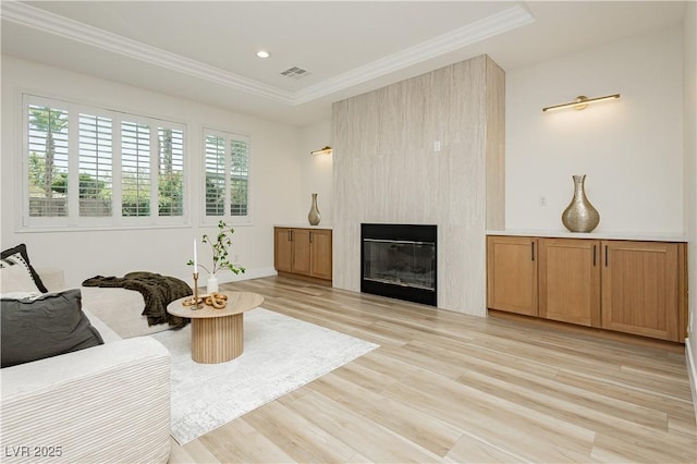 4493 Rometta Ave, Las Vegas, NV 89141 - living area featuring light wood-type flooring, a large fireplace, ornamental molding, recessed lighting, and a tray ceiling