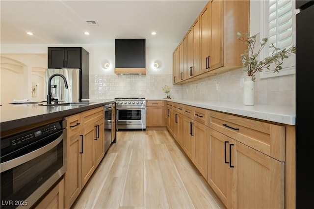 4493 Rometta Ave, Las Vegas, NV 89141 - kitchen with appliances with stainless steel finishes, wall chimney range hood, decorative backsplash, light wood-style floors, and light countertops