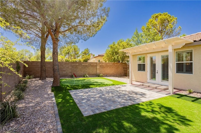 4493 Rometta Ave, Las Vegas, NV 89141 - fenced backyard with an area to practice putting, a patio area, french doors, and a pergola