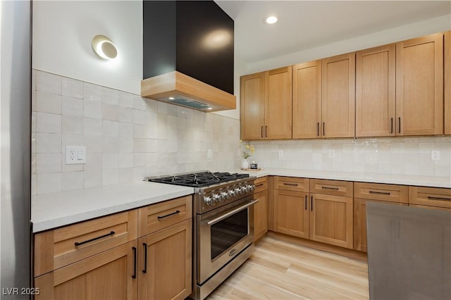 4493 Rometta Ave, Las Vegas, NV 89141 - kitchen featuring high end stainless steel range oven, custom range hood, light countertops, tasteful backsplash, and light wood-type flooring