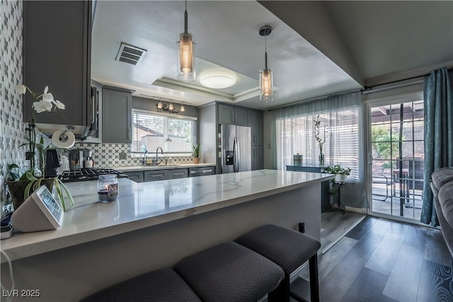 4129 Ridgewood Ave, Las Vegas, NV 89120 - kitchen featuring appliances with stainless steel finishes, gray cabinets, a raised ceiling, and dark wood finished floors