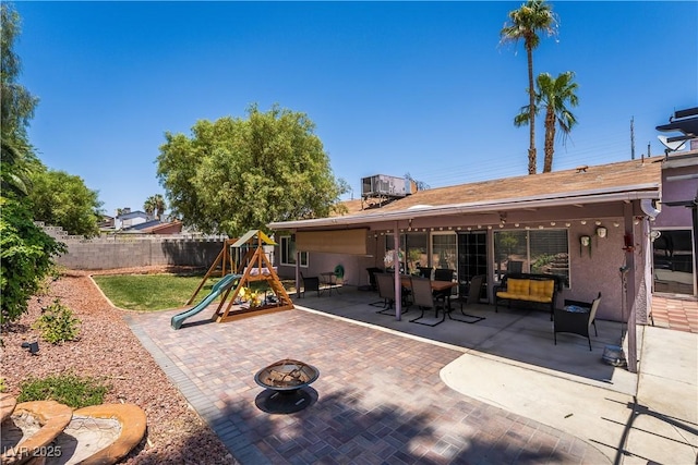 4129 Ridgewood Ave, Las Vegas, NV 89120 - fenced backyard featuring a patio, a playground, and an outdoor fire pit
