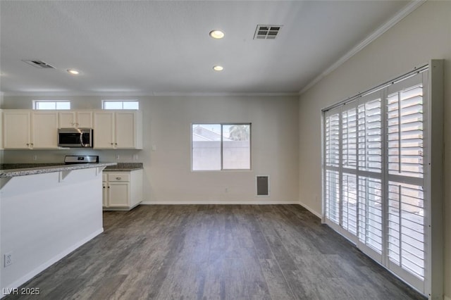 1453 Doggett Ave, Las Vegas, NV 89123 - kitchen featuring stainless steel microwave, dark wood-style flooring, crown molding, recessed lighting, and white cabinets