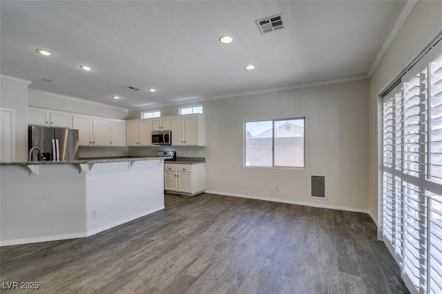 1453 Doggett Ave, Las Vegas, NV 89123 - kitchen featuring stainless steel appliances, crown molding, a breakfast bar area, recessed lighting, and dark stone counters