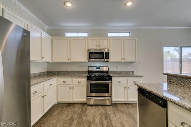 1453 Doggett Ave, Las Vegas, NV 89123 - kitchen with stainless steel appliances, wood finished floors, ornamental molding, recessed lighting, and light stone countertops