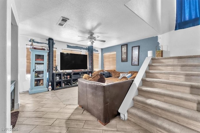 5612 Royal Castle Ln, Las Vegas, NV 89130 - living room featuring a ceiling fan, stairway, and a textured ceiling
