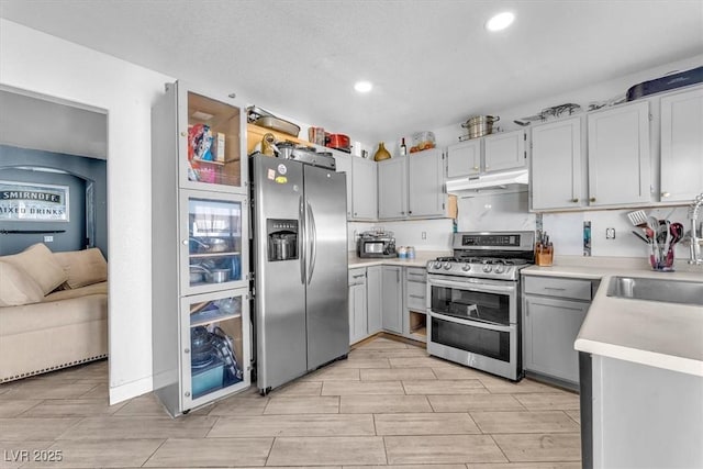 5612 Royal Castle Ln, Las Vegas, NV 89130 - kitchen featuring stainless steel appliances, under cabinet range hood, light countertops, recessed lighting, and wood tiled floors