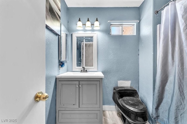 5612 Royal Castle Ln, Las Vegas, NV 89130 - full bathroom featuring vanity, a textured wall, wood finished floors, and curtained shower