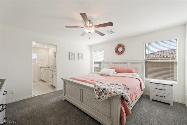 7730 Moore Creek Ln, North Las Vegas, NV 89084 - bedroom featuring light carpet, multiple windows, a ceiling fan, and connected bathroom