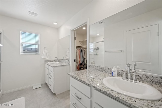 7730 Moore Creek Ln, North Las Vegas, NV 89084 - full bath with a stall shower, two vanities, a spacious closet, and tile patterned flooring