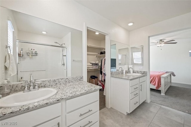 7730 Moore Creek Ln, North Las Vegas, NV 89084 - full bathroom with two vanities, a stall shower, ceiling fan, tile patterned floors, and a walk in closet