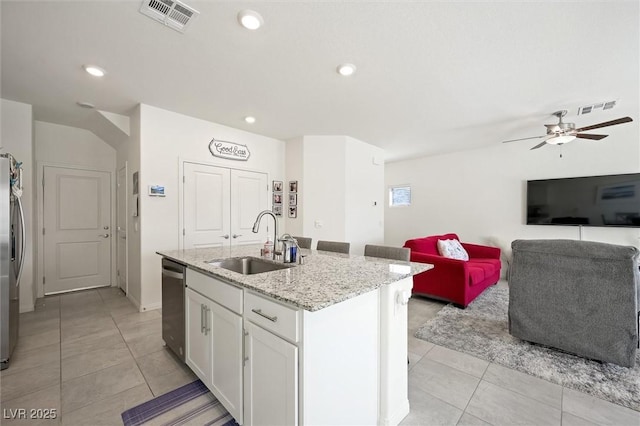 7730 Moore Creek Ln, North Las Vegas, NV 89084 - kitchen featuring stainless steel appliances, light tile patterned floors, an island with sink, white cabinets, and light stone countertops