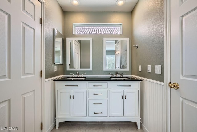 6125 Broken Slate Way, Las Vegas, NV 89139 - bathroom with double vanity, wainscoting, tile patterned floors, a textured wall, and plenty of natural light