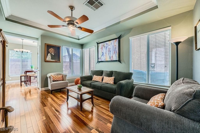 6125 Broken Slate Way, Las Vegas, NV 89139 - living area with a tray ceiling, ornamental molding, hardwood / wood-style flooring, a chandelier, and a ceiling fan