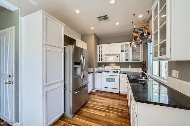 6125 Broken Slate Way, Las Vegas, NV 89139 - kitchen with white appliances, wood finished floors, white cabinetry, recessed lighting, and glass insert cabinets