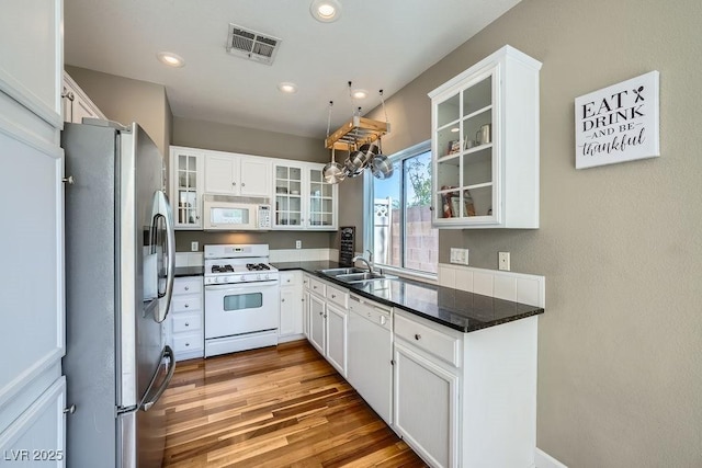 6125 Broken Slate Way, Las Vegas, NV 89139 - kitchen featuring white appliances, dark countertops, white cabinets, wood finished floors, and recessed lighting