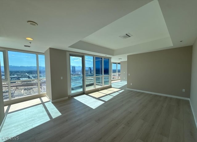 4525 Dean Martin Dr Unit 2704, Las Vegas, NV 89103 - spare room with a raised ceiling, expansive windows, and wood finished floors