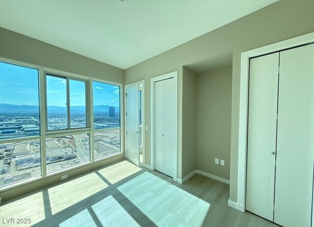 4525 Dean Martin Dr Unit 2704, Las Vegas, NV 89103 - unfurnished bedroom with multiple closets and light wood finished floors
