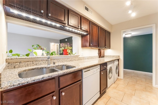 2866 Loveland Dr Unit 2018, Las Vegas, NV 89109 - kitchen featuring dishwasher, separate washer and dryer, light stone counters, and light tile patterned floors