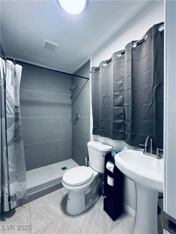 5821 Marka Dr, Las Vegas, NV 89108 - full bath featuring tiled shower, a textured ceiling, and tile patterned floors