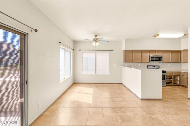 4830 Grey Wolf Ln Unit 104, Las Vegas, NV 89149 - kitchen featuring stainless steel appliances, a ceiling fan, light countertops, a peninsula, and light tile patterned floors