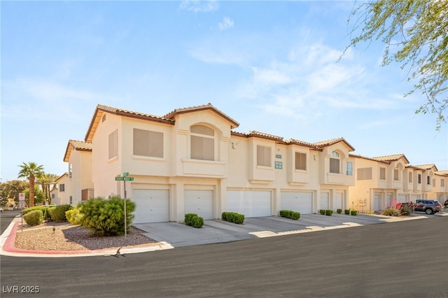 4830 Grey Wolf Ln Unit 104, Las Vegas, NV 89149 - view of front of house featuring an attached garage, a tile roof, stucco siding, and driveway