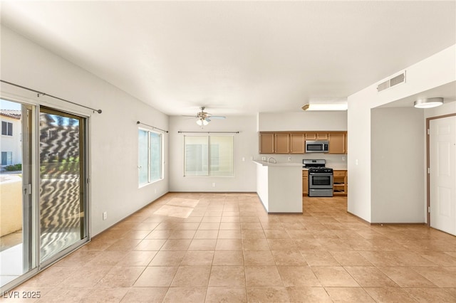 4830 Grey Wolf Ln Unit 104, Las Vegas, NV 89149 - kitchen with stainless steel appliances, light countertops, a ceiling fan, light tile patterned floors, and a peninsula