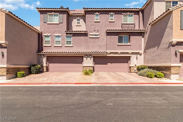 10013 Sable Point St, Las Vegas, NV 89178 - view of front facade featuring driveway, stone siding, a garage, and stucco siding