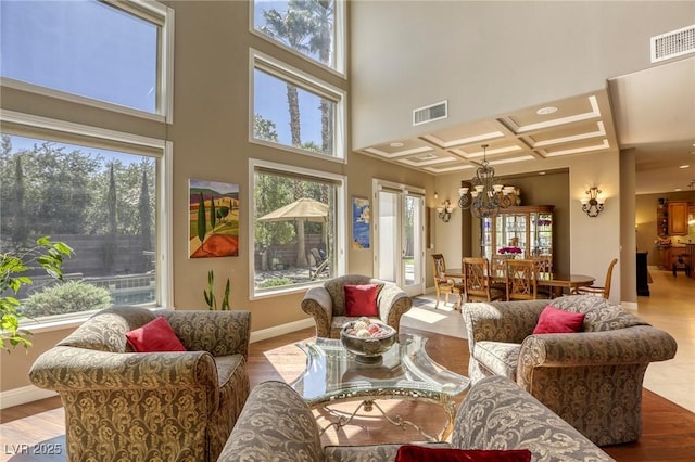 2008 Winter Wind St, Las Vegas, NV 89134 - living room featuring a chandelier, a towering ceiling, wood finished floors, and coffered ceiling