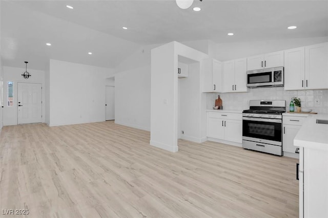 2832 Sing Song Way, Las Vegas, NV 89106 - kitchen featuring stainless steel appliances, vaulted ceiling, light countertops, decorative backsplash, and white cabinetry