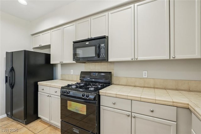 3609 Kingfishers Catch Ave, North Las Vegas, NV 89084 - kitchen with black appliances, tile counters, white cabinetry, and light tile patterned floors