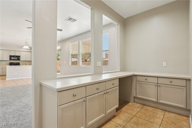 3609 Kingfishers Catch Ave, North Las Vegas, NV 89084 - kitchen featuring black microwave, light tile patterned floors, range, and light countertops