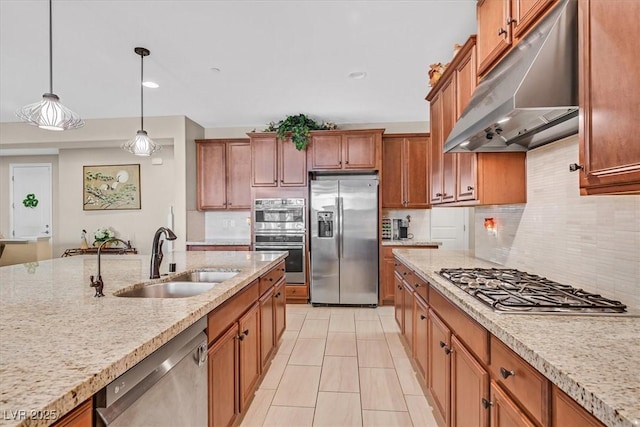2194 Trivero St, Henderson, NV 89044 - kitchen with appliances with stainless steel finishes, under cabinet range hood, brown cabinetry, backsplash, and decorative light fixtures