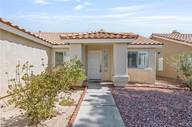 6209 Lenaking Ave, Las Vegas, NV 89122 - view of exterior entry with a tile roof and stucco siding