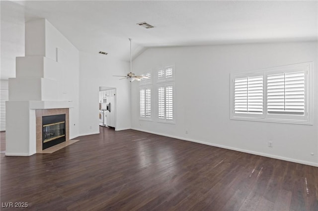 6209 Lenaking Ave, Las Vegas, NV 89122 - unfurnished living room featuring vaulted ceiling, dark wood-type flooring, a ceiling fan, and a tiled fireplace