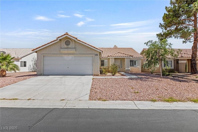 6209 Lenaking Ave, Las Vegas, NV 89122 - view of front of home with a tiled roof, stucco siding, an attached garage, and driveway
