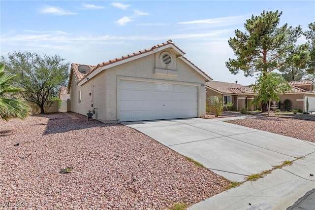 6209 Lenaking Ave, Las Vegas, NV 89122 - view of front of home featuring a garage, concrete driveway, a tile roof, and stucco siding