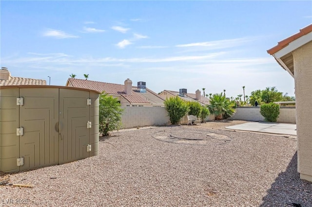 6209 Lenaking Ave, Las Vegas, NV 89122 - fenced backyard with a storage unit and a patio area