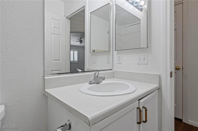 6209 Lenaking Ave, Las Vegas, NV 89122 - bathroom with a textured wall, vanity, and a ceiling fan