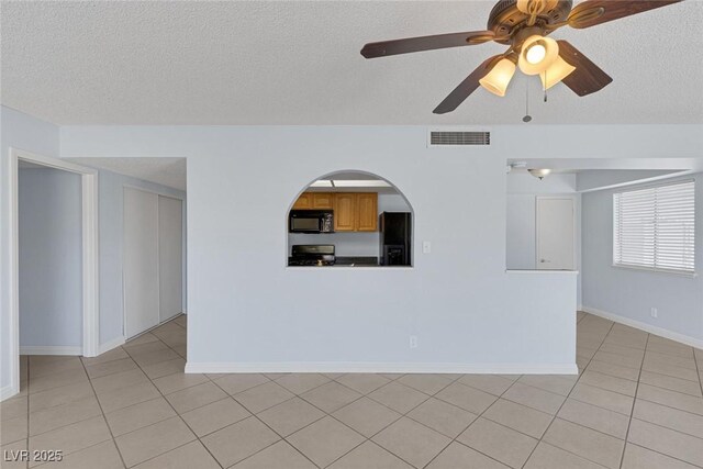 4784 El Escorial Dr, Las Vegas, NV 89121 - unfurnished living room featuring a textured ceiling, light tile patterned floors, and a ceiling fan