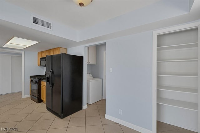 4784 El Escorial Dr, Las Vegas, NV 89121 - kitchen featuring black appliances, light tile patterned floors, washing machine and dryer, and light brown cabinetry