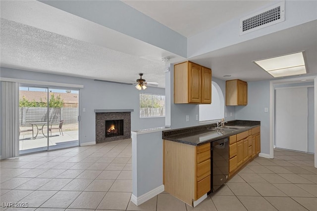 4784 El Escorial Dr, Las Vegas, NV 89121 - kitchen with dishwasher, light tile patterned flooring, dark countertops, a lit fireplace, and open floor plan
