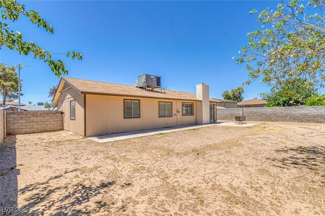 4784 El Escorial Dr, Las Vegas, NV 89121 - rear view of house featuring a fenced backyard, a patio area, and a chimney
