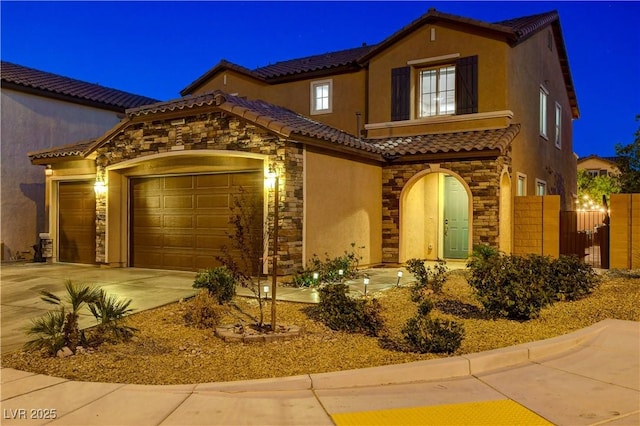 7311 Spring Flower Ave, Las Vegas, NV 89117 - mediterranean / spanish house featuring stone siding, stucco siding, a tile roof, an attached garage, and concrete driveway