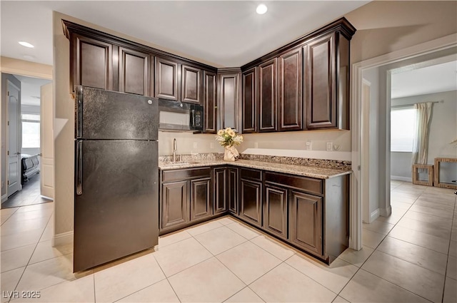 7311 Spring Flower Ave, Las Vegas, NV 89117 - kitchen with black appliances, dark brown cabinets, light stone countertops, light tile patterned flooring, and recessed lighting