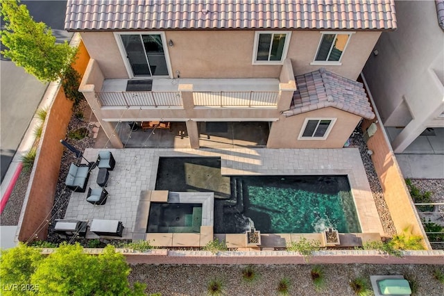 7311 Spring Flower Ave, Las Vegas, NV 89117 - rear view of house featuring a balcony, a tiled roof, stucco siding, and a fenced backyard