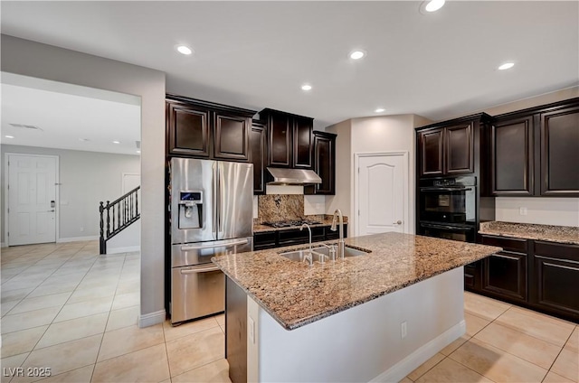 7311 Spring Flower Ave, Las Vegas, NV 89117 - kitchen featuring stainless steel refrigerator with ice dispenser, under cabinet range hood, light stone counters, tasteful backsplash, and a kitchen island with sink